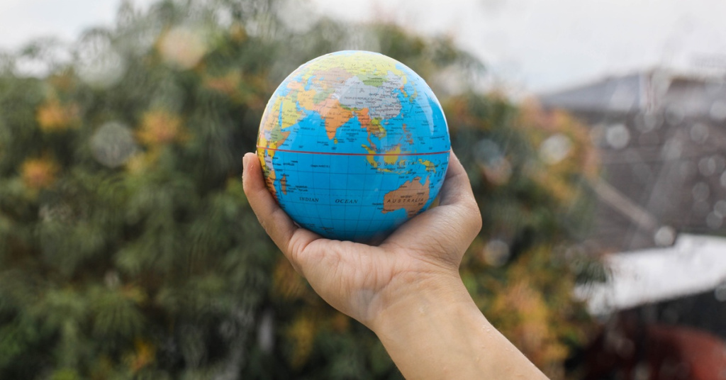 globe in hand with nature background