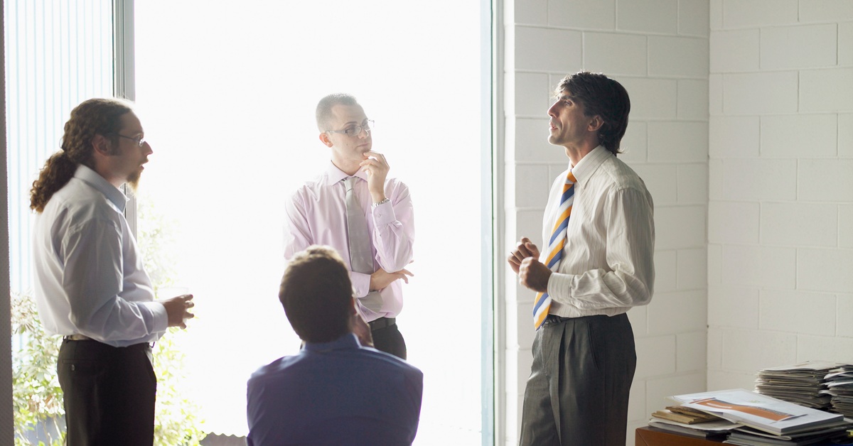 group of men talking in office