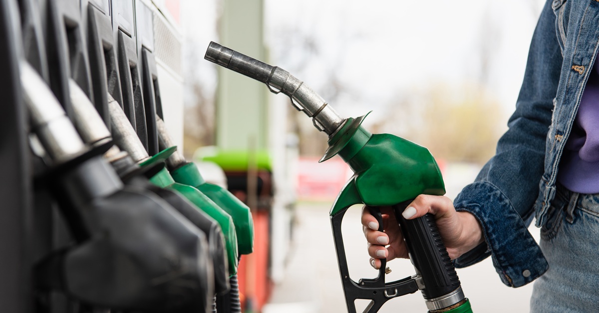 woman holding green gas pump