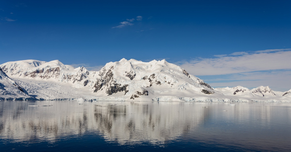 snowy mountains reflecting on water