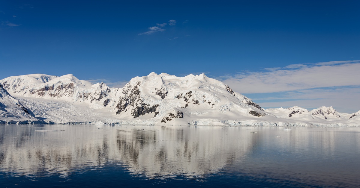 snowy mountains reflecting on water